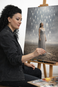 Antoinette Francis auteur et peintre peignant un tableau où la pluie symbolise l’origine de la vie et la mémoire du temps